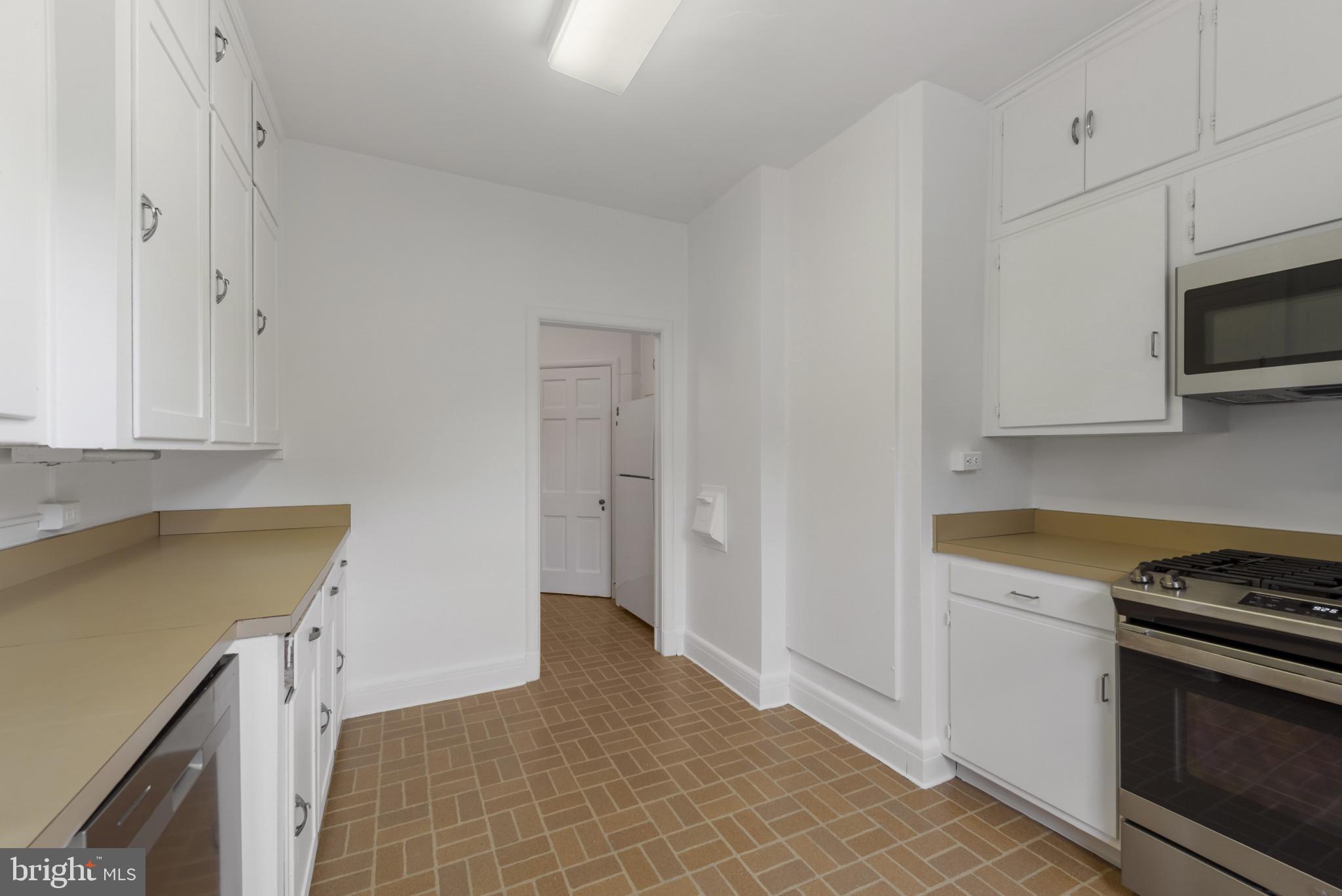 6 Upland Road, Unit F5 Baltimore, MD 21210 - Photo 12 of 31 a kitchen with stainless steel appliances white cabinets and a stove