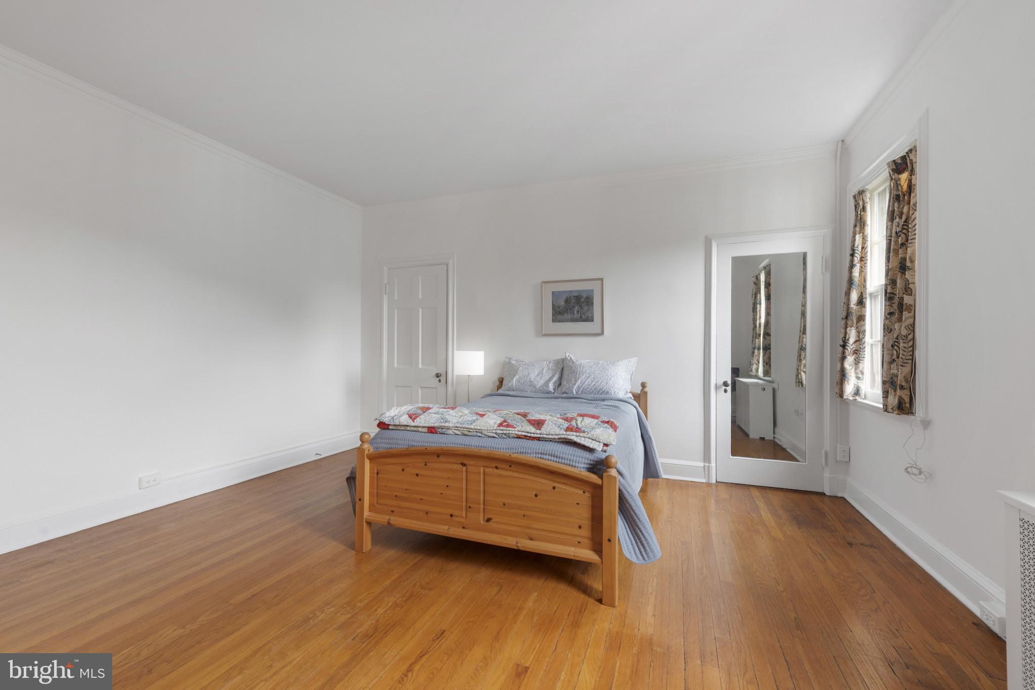 6 Upland Road, Unit F5 Baltimore, MD 21210 - Photo 19 of 31 a bedroom with a bed and wooden floor