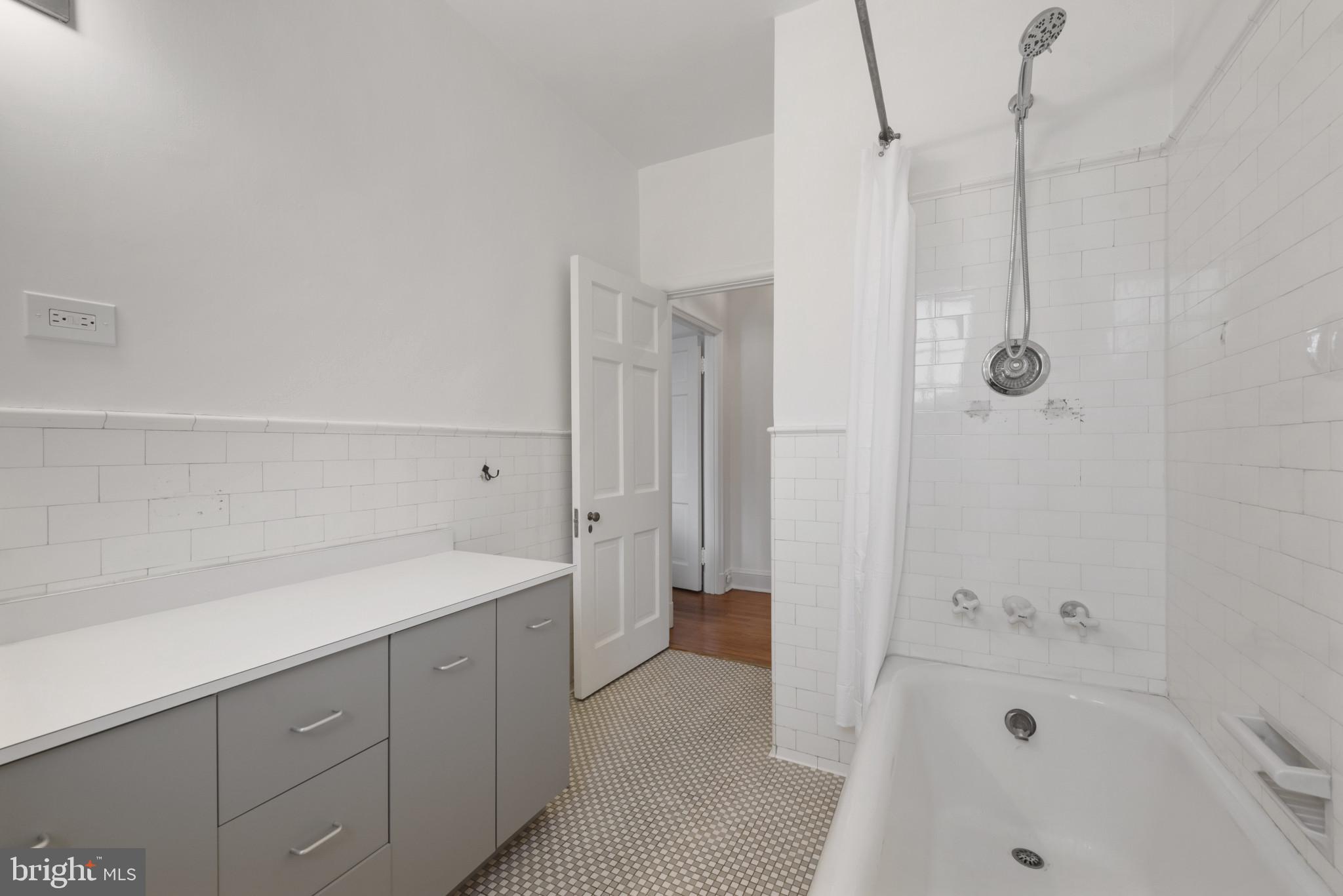 6 Upland Road, Unit F5 Baltimore, MD 21210 - Photo 23 of 31 a bathroom with a tub sink a mirror and a shower