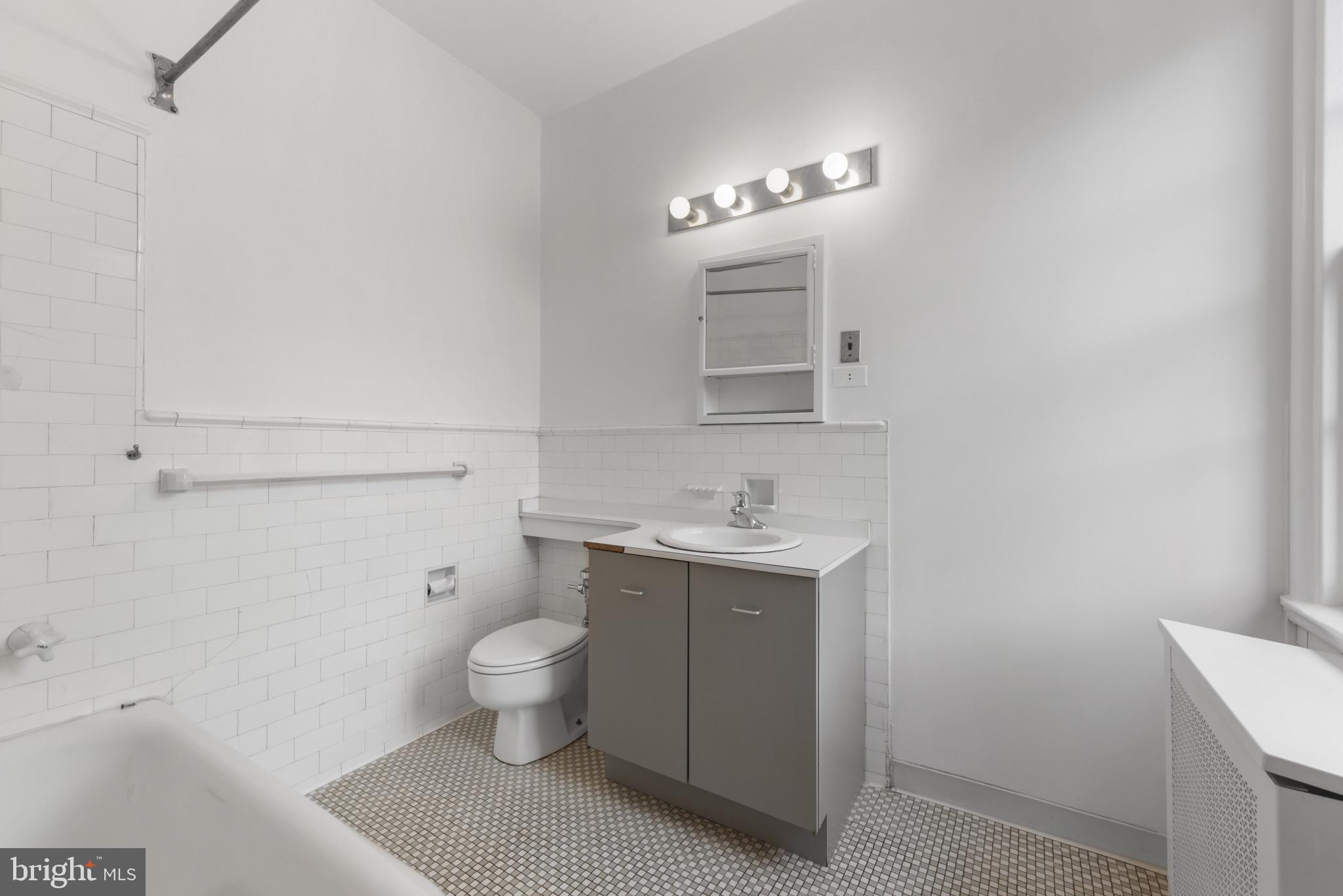 6 Upland Road, Unit F5 Baltimore, MD 21210 - Photo 27 of 31 a bathroom with a toilet sink and mirror