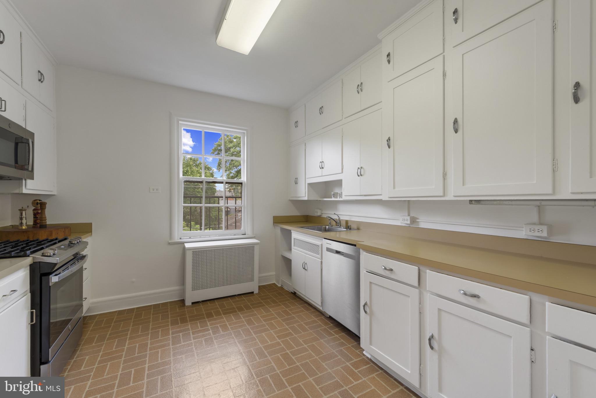 6 Upland Road, Unit F5 Baltimore, MD 21210 - Photo 10 of 31 a kitchen with granite countertop white cabinets and white appliances