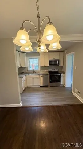 a kitchen with stainless steel appliances granite countertop a stove and a wooden floors