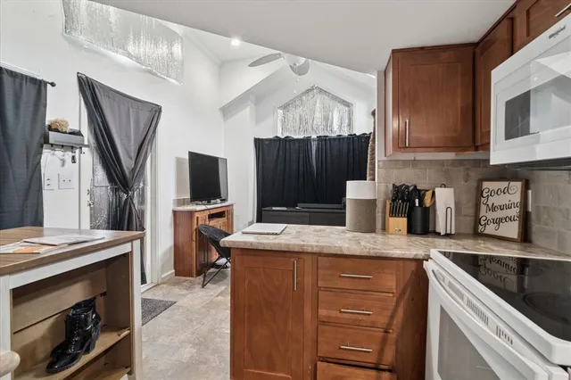 a kitchen with kitchen island granite countertop a sink appliances and cabinets