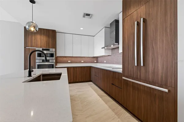 a kitchen with stainless steel appliances granite countertop a refrigerator a sink and a stove
