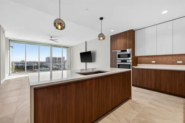 a kitchen with stainless steel appliances a large counter top a sink and a refrigerator