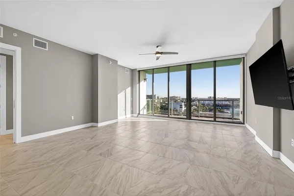 a view of an empty room with windows and a flat screen tv