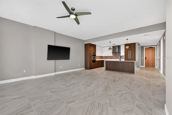 a view of a livingroom with a flat screen tv wooden floor and ceiling fan