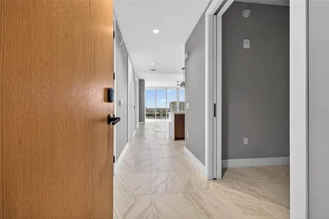 a view of a hallway with a dining table and a refrigerator
