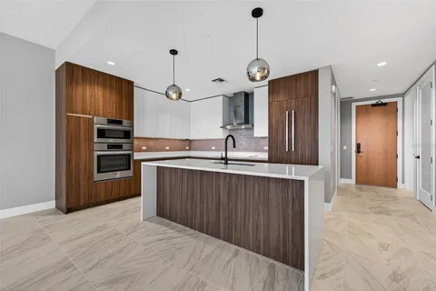 a kitchen with kitchen island a counter space a sink and stainless steel appliances