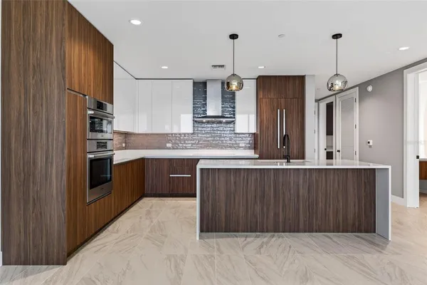 a kitchen with stainless steel appliances granite countertop a refrigerator a sink dishwasher a kitchen island with wooden cabinets and floor