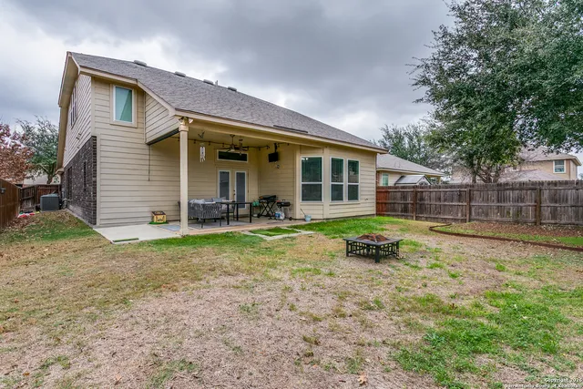 a view of a house with backyard and sitting area