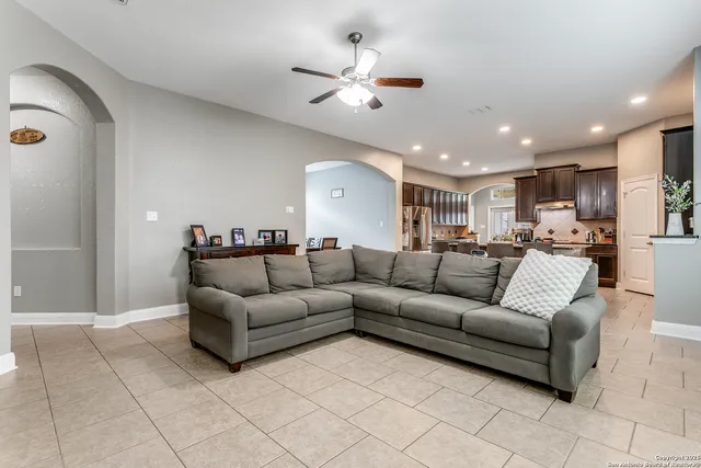 a living room with furniture and a ceiling fan