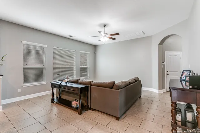 a living room with furniture and two windows