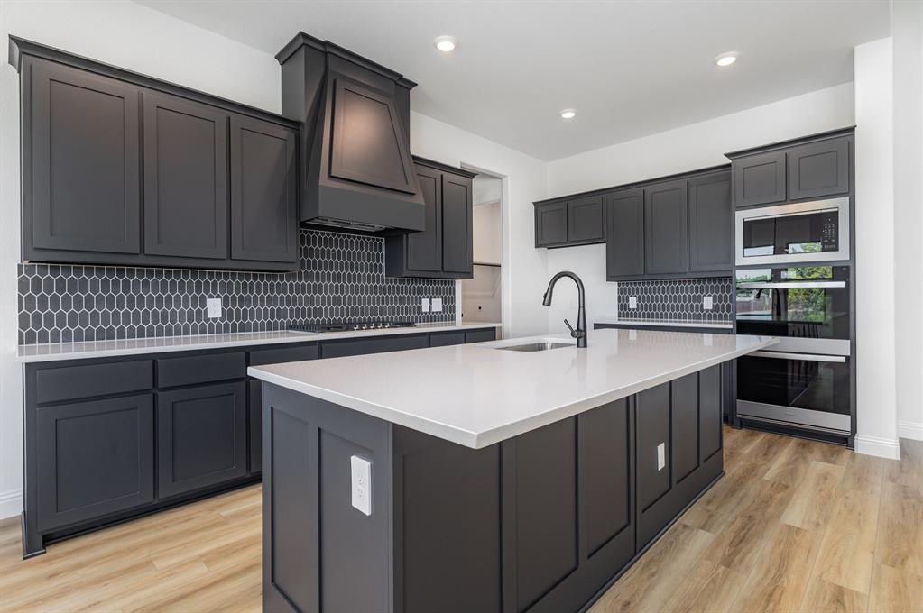 6841 Hayes Road Midlothian, TX 76065 - Photo 12 of 27 a kitchen with kitchen island granite countertop a sink stove and cabinets