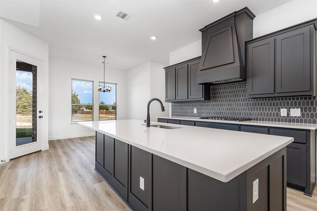 6841 Hayes Road Midlothian, TX 76065 - Photo 13 of 27 a kitchen with kitchen island a sink appliances and cabinets