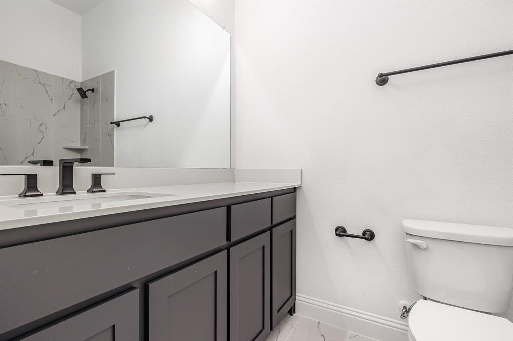 6841 Hayes Road Midlothian, TX 76065 - Photo 22 of 27 a bathroom with a sink a toilet a vanity and mirror