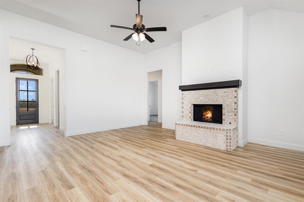 6841 Hayes Road Midlothian, TX 76065 - Photo 6 of 27 a view of empty room with wooden floor fireplace and window