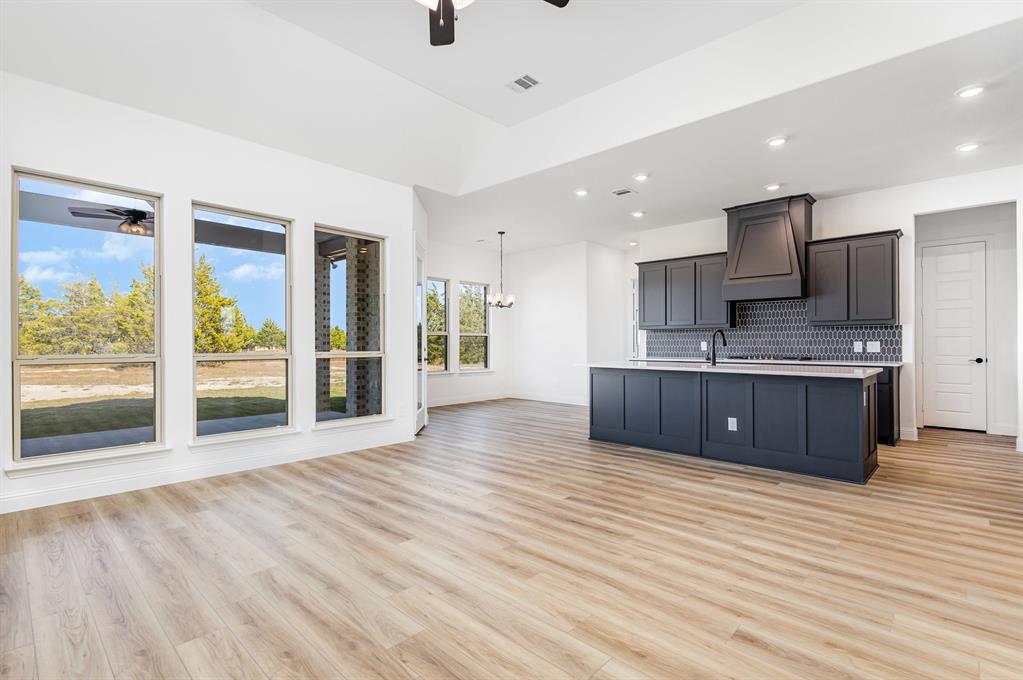 6841 Hayes Road Midlothian, TX 76065 - Photo 8 of 27 a large kitchen with stainless steel appliances kitchen island a large counter top and wooden floors