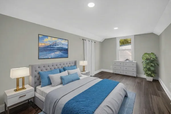 a spacious bedroom with a bed a couch and a window