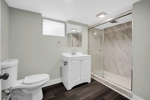 a bathroom with a sink a toilet and shower