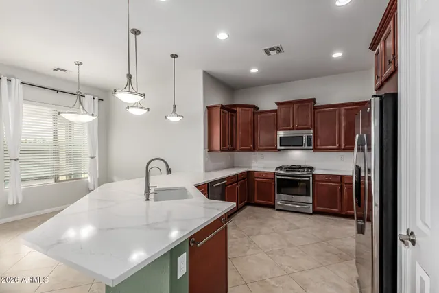 a kitchen with stainless steel appliances granite countertop a sink a stove and a refrigerator