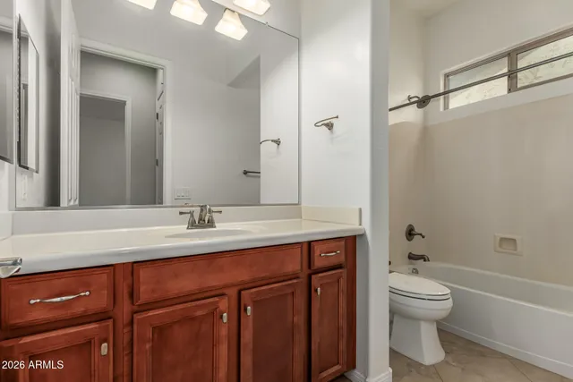 a bathroom with a granite countertop sink toilet a large mirror a bathtub and shower