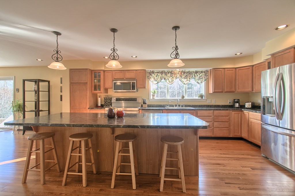 112 Beaman Road Princeton, MA 01541 - Photo 4 of 30 a kitchen with stainless steel appliances granite countertop wooden floor window and white cabinets