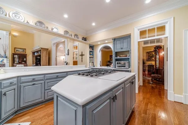 a kitchen with granite countertop a dining table chairs workspace living room and wooden floor