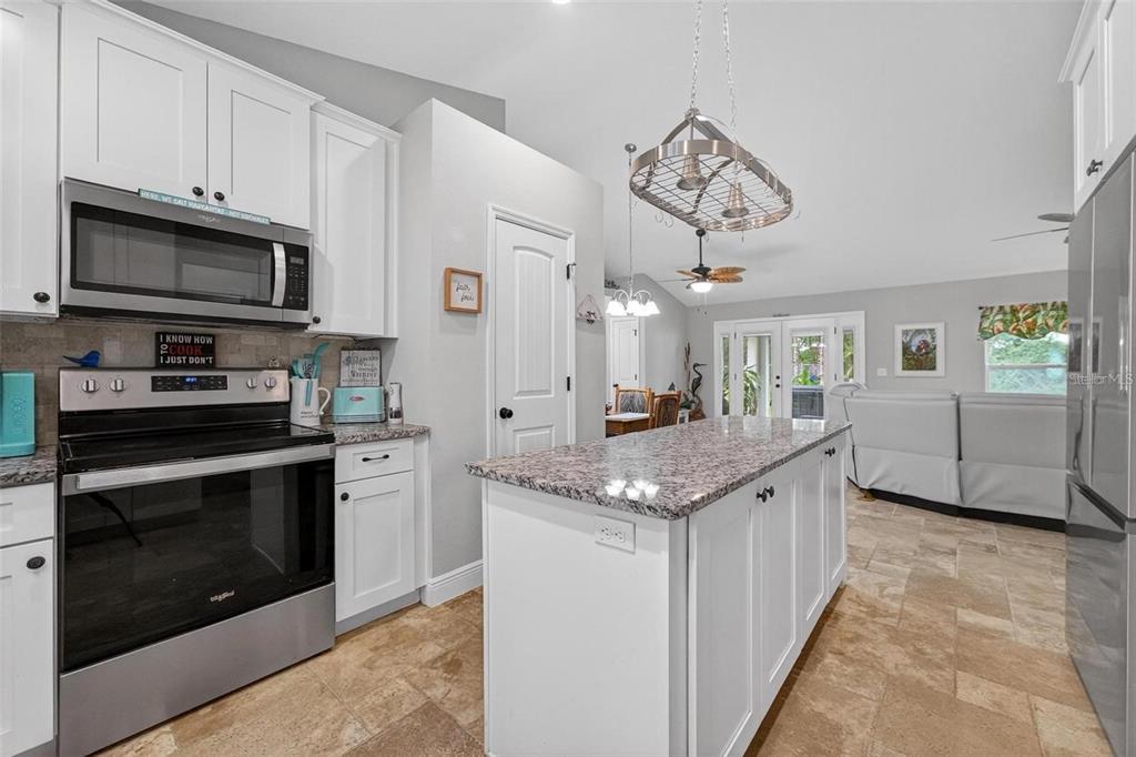 8160 Southeast 164th Place Summerfield, FL 34491 - Photo 12 of 56 a kitchen with stainless steel appliances granite countertop a stove a microwave and a refrigerator