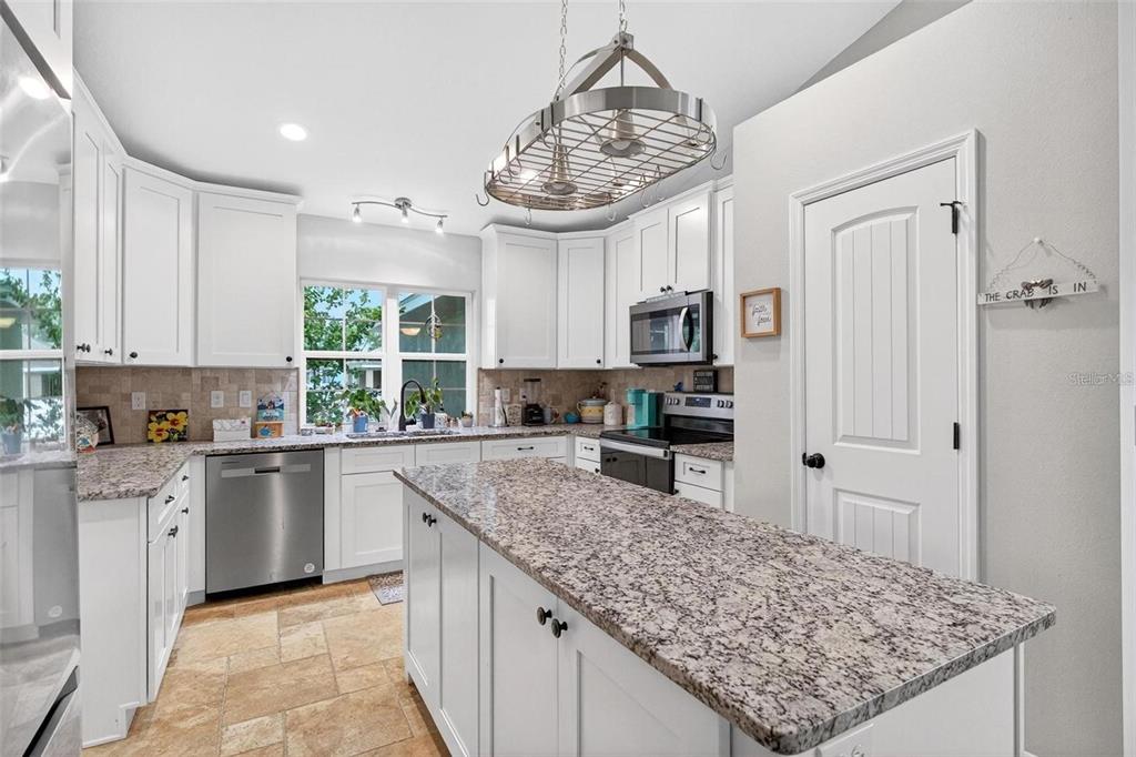 8160 Southeast 164th Place Summerfield, FL 34491 - Photo 15 of 56 a kitchen with stainless steel appliances granite countertop a sink stove and refrigerator