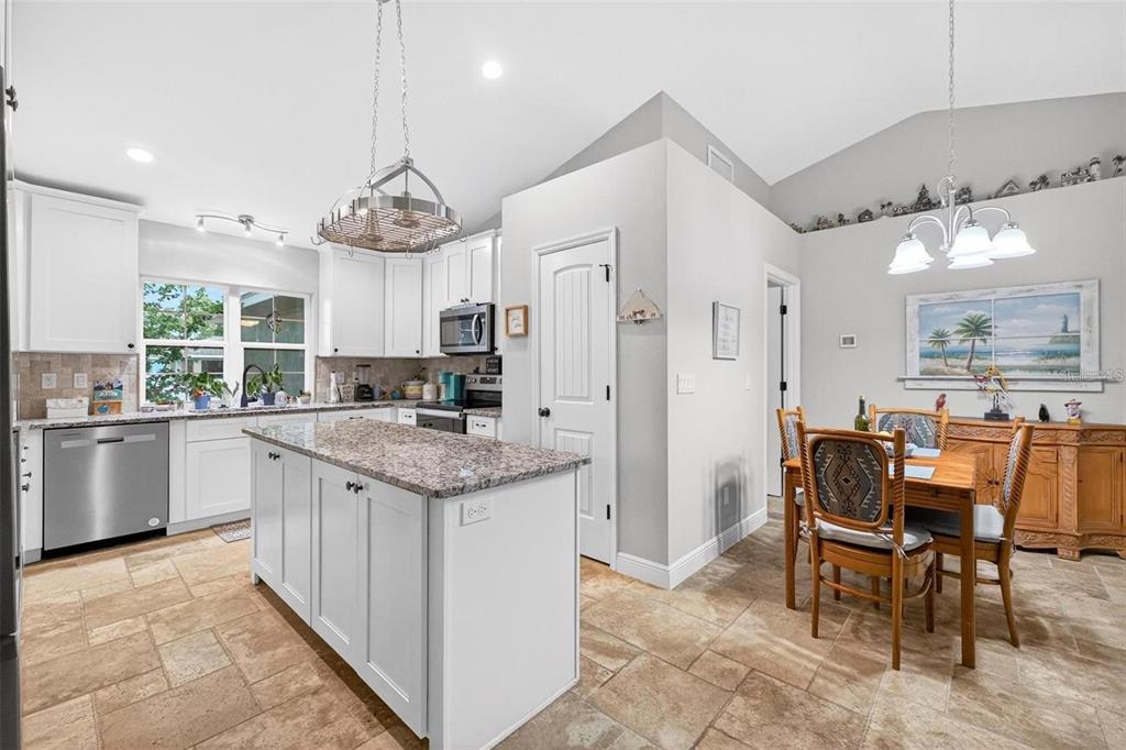 8160 Southeast 164th Place Summerfield, FL 34491 - Photo 16 of 56 a kitchen with granite countertop cabinets a dining table and chairs