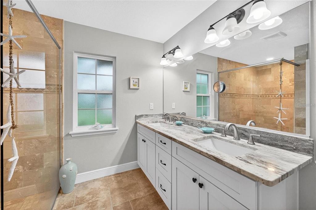 8160 Southeast 164th Place Summerfield, FL 34491 - Photo 30 of 56 a bathroom with a granite countertop sink a large mirror and a shower