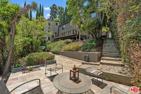 a view of a house with backyard sitting area and garden