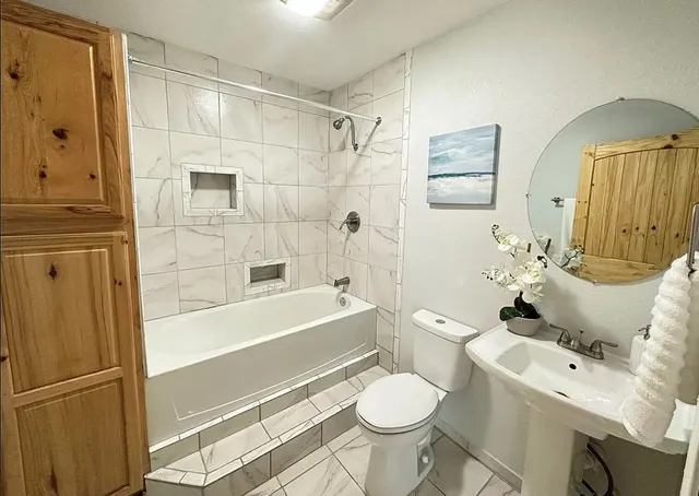 a bathroom with a sink toilet and shower