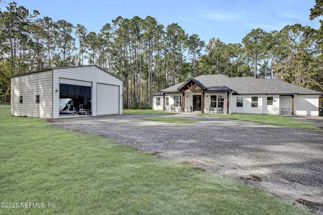 a front view of a house with yard and tree