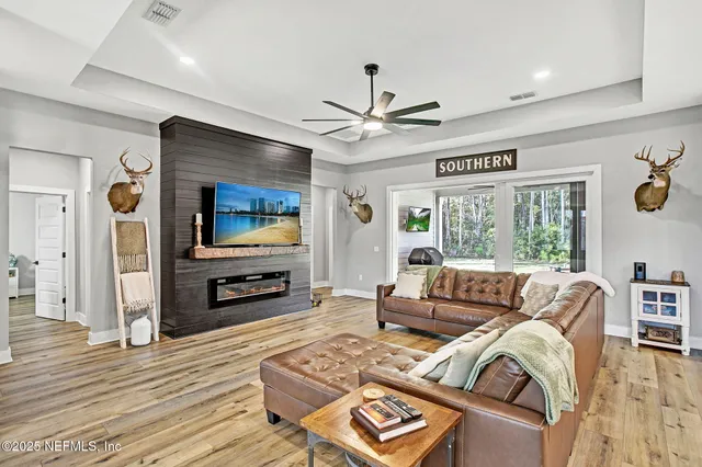 a living room with furniture flat screen tv and wooden floor