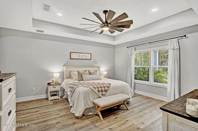 a bedroom with a large bed and a chandelier
