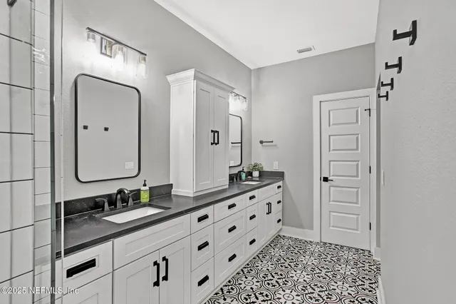 a bathroom with a double vanity sink and a mirror