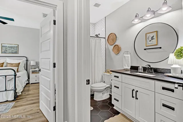 a bathroom with a double vanity sink mirror and toilet