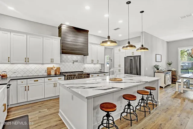 a kitchen with a dining table chairs sink and stove