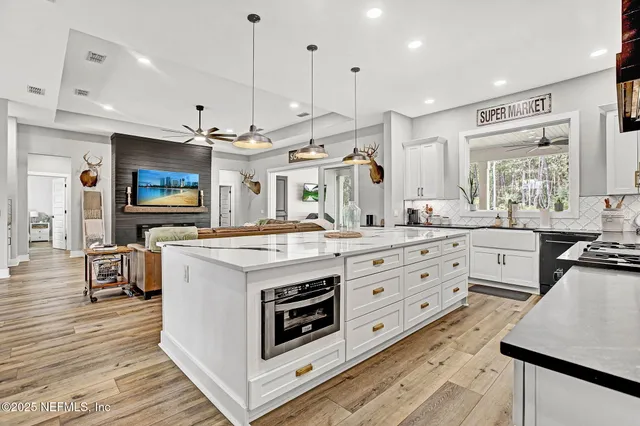 a kitchen with stainless steel appliances granite countertop a stove cabinets and wooden floor