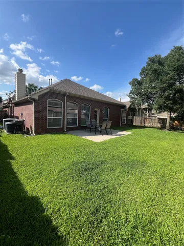 a view of a house with a yard and sitting area