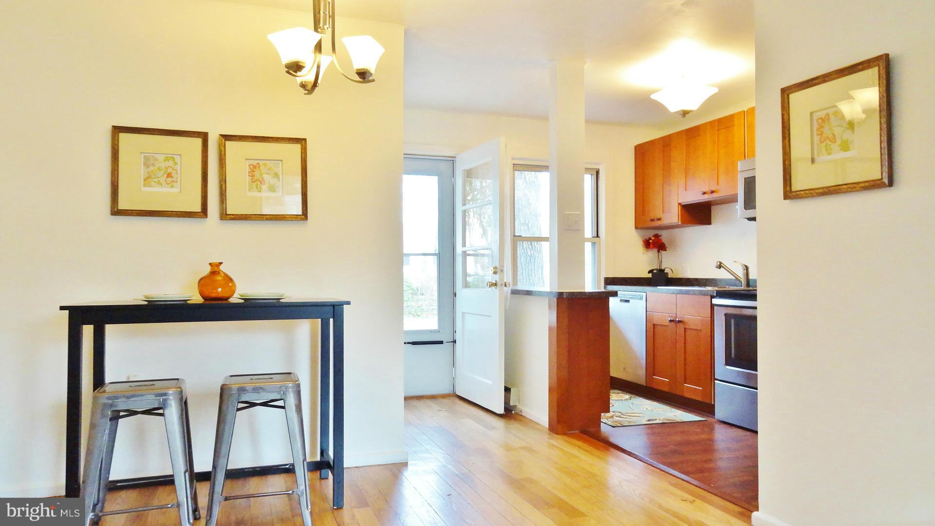 51 Ridge Road, Unit B Greenbelt, MD 20770 - Photo 6 of 8 a kitchen with stainless steel appliances granite countertop a refrigerator a stove and a sink with wooden floor