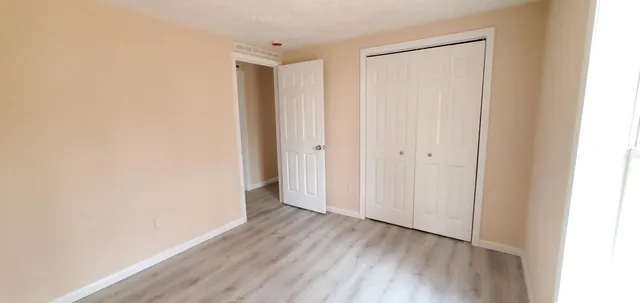 a view of an empty room with wooden floor