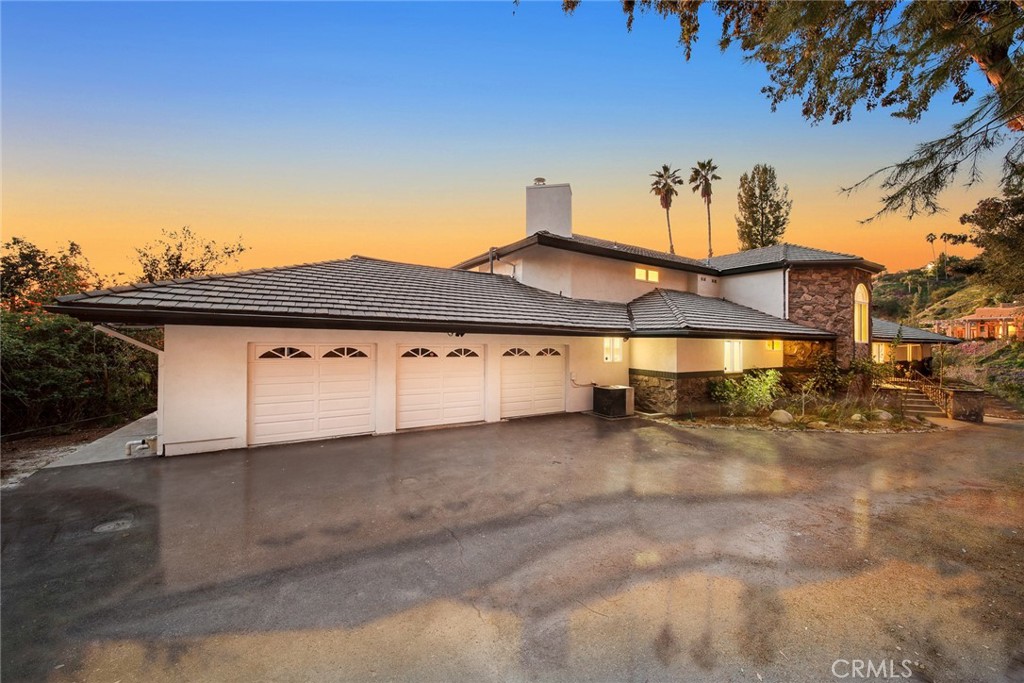 a view of a white house with a large window and a yard