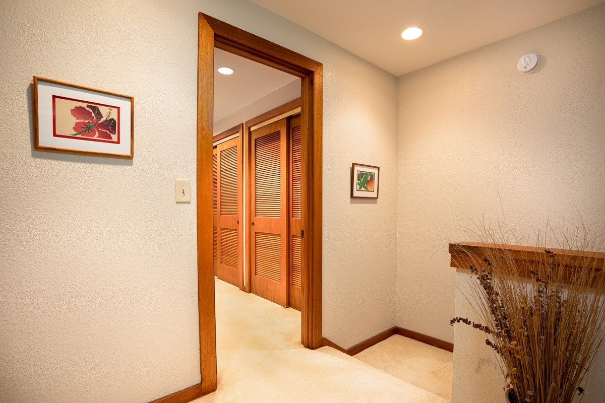 2221 Kapili Road, Unit 52 Koloa, HI 96756 - Photo 14 of 26 a view of a hallway with paintings on the wall