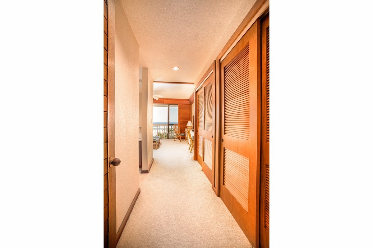 2221 Kapili Road, Unit 52 Koloa, HI 96756 - Photo 9 of 26 a view of a hallway with paintings on the walls