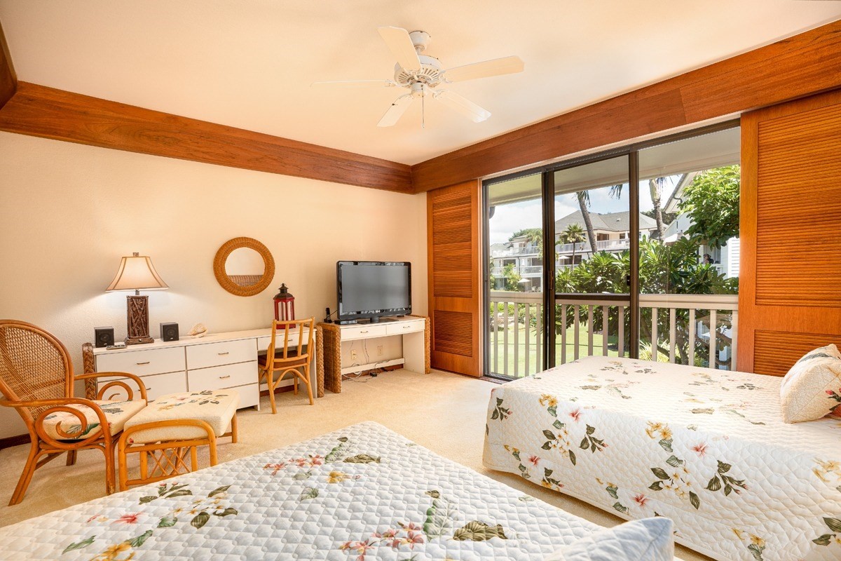 2221 Kapili Road, Unit 52 Koloa, HI 96756 - Photo 10 of 26 a bedroom with a bed a flat screen tv and balcony