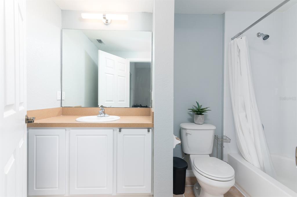 4850 Southwest 91 Terrace, Unit 301 Gainesville, FL 32608 - Photo 12 of 24 a bathroom with a granite countertop sink a toilet a mirror and shower