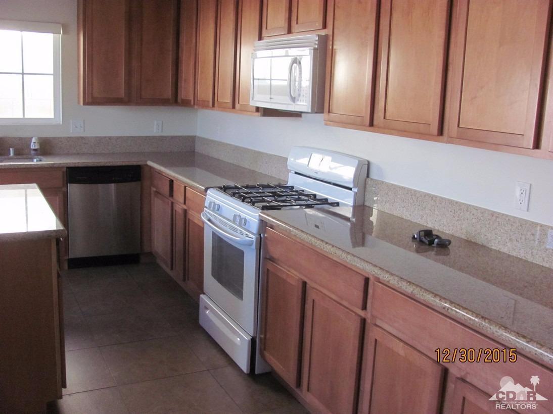 68275 Tortuga Road Cathedral City, CA 92234 - Photo 16 of 18 a kitchen with granite countertop a sink a stove and cabinets
